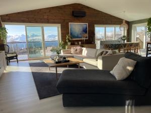 a living room with couches and a view of the mountains at Exclusive view villa in Tromsø