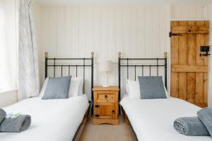 dos camas sentadas una al lado de la otra en una habitación en Froxfield Cottage en Langton Matravers