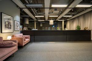 a waiting room with pink furniture and a counter at Stockholm Hotel Apartments Arlanda XPO in Arlanda