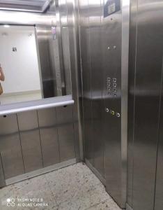 un ascensor en un edificio con puerta y espejo en Souza Lofts Centro Praça Tiradentes, en Teófilo Otoni