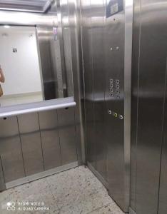 un ascensor en un edificio con puerta y espejo en Souza Lofts Centro Praça Tiradentes en Teófilo Otoni