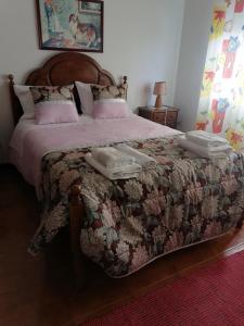 a bedroom with a large bed with two towels on it at Propriedade dos Seixos in Moledo
