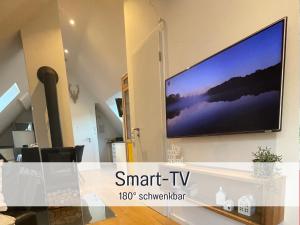 einen Flachbild-TV, der an einer Wand hängt in der Unterkunft Ferienwohnung Auszeit Dachstudio in Sulzburg