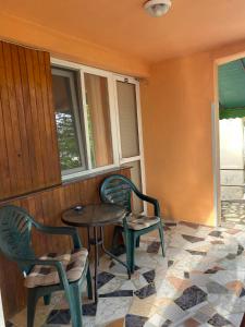a porch with two chairs and a table and a window at Family Hotel Julian in Kranevo