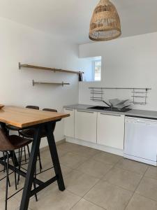 a kitchen with a wooden table and a table and chairs at Brise lame in Saint-Cast-le-Guildo