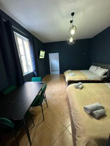 pokój z 2 łóżkami, stołem i jadalnią w obiekcie Tirana Rooms w Tiranie