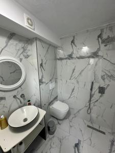 ティラナにあるTirana Roomsの白いバスルーム(洗面台、トイレ付)