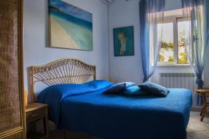 バイア・ドミツィアにあるVilla Ferreroのベッドルーム1室(青いベッド1台、枕2つ付)