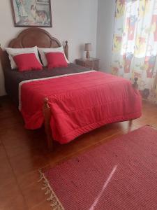 1 dormitorio con 1 cama grande con manta roja en Propriedade dos Seixos, en Moledo