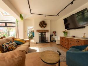 uma sala de estar com um sofá e uma televisão de ecrã plano em Pass the Keys Acorn Lodge · Luxury Retreat In a Stunning Oasis With Hot Tub em Market Drayton