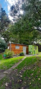 a small house with a green garage in a yard at Cabañas El Nono in Tandil