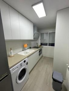 een keuken met een wasmachine en een wastafel bij Apartamento nuevo en Puertollano in Puertollano