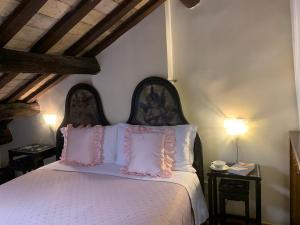 - une chambre avec un lit doté d'oreillers roses et blancs dans l'établissement Appartamento nel centro storico., à Rome