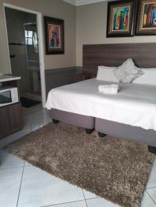 a bedroom with a large bed and a rug at Sunrise Boutique Hotel in Witbank