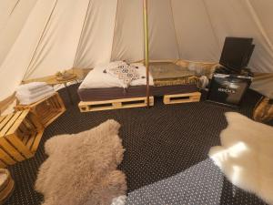 a room with a tent with a bed and a tv at Punt-A-Pacha Glamping mit eigenem Garten in Kolonie Zern