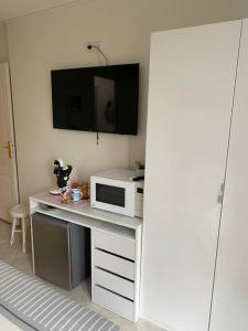 a kitchen with a desk with a microwave and a tv at chambre avec entrée indépendante situation idéale in Serris
