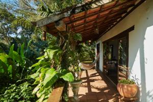 a porch of a house with plants on it at Pousada Picinguaba in Ubatuba