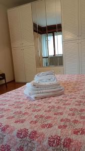una pila de toallas sentadas encima de una cama en Oasi verde Susa città, en Susa