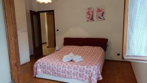Dormitorio pequeño con cama con manta rosa en Oasi verde Susa città, en Susa