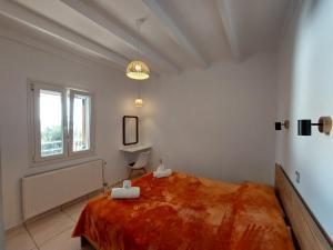 a bedroom with a large bed and a window at Villa Tramonto in Lévki