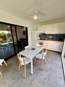 a kitchen with a table and chairs in a room at Appartement en rez-de-jardin in Baie Nettle