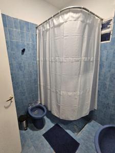 ein Badezimmer mit Toilette und Duschvorhang in der Unterkunft Casa de Mayo in Tinogasta