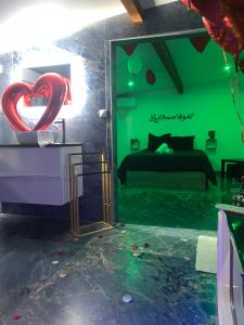 um quarto verde com uma cama e um coração no chão em La Dream Night em Pontault-Combault