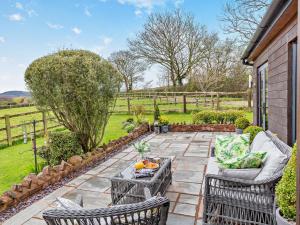 a patio with two wicker chairs and a table at 1 Bed in Nether Stowey 36190 in Nether Stowey