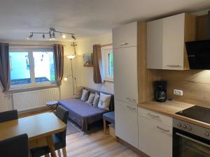 a kitchen and living room with a couch and a table at Ferienhaus Lipp in Mittenwald