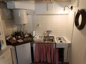 a small kitchen with a stove and a sink at Hobbit house lubenice in Lubenice