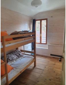 a room with two bunk beds in a cabin at Grand appartement terrasse au coeur des Bauges in Le Châtelard