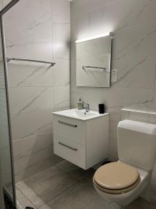 een witte badkamer met een toilet en een wastafel bij Hotel Restaurant du Moulin in Fleurier