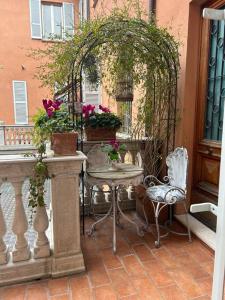 um pátio exterior com uma mesa, cadeiras e flores em Centro storico Residenza di charme em Rimini