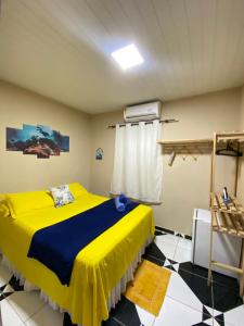 a bedroom with a yellow bed in a room at Casa Silveira NORONHA in Fernando de Noronha