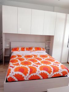 een slaapkamer met een bed met een oranje en wit dekbed bij casArancia in Rome