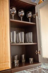 a kitchen pantry with wine glasses and plates at Babylon Apartments On Soborna in Rivne