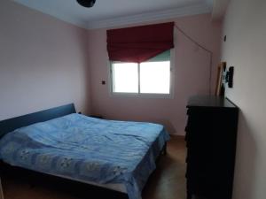 a small bedroom with a bed and a window at Naila in Sidi Bouzid