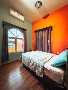 Casa Sunset في فلوريس: غرفة نوم بسرير بحائط برتقالي