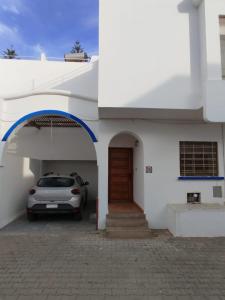 a car parked in front of a white building at Naila in Sidi Bouzid