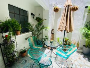 a patio with a table and chairs and an umbrella at Hotel 17-52 in Guatemala