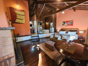 a living room with a bed and a table at Estalagem Wiesbaden in Monte Verde +128 photos