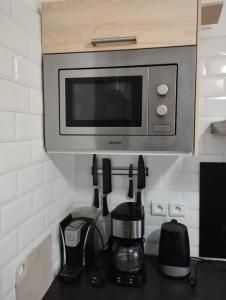 a microwave above a kitchen counter with a coffee maker at Naila in Sidi Bouzid