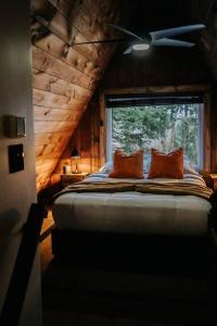 a bedroom with a bed with two pillows and a window at NEW! Cozy & Modern A-Frame in the woods w/HOT TUB in Tamworth