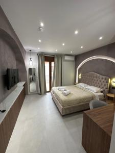 um quarto com uma cama grande e uma televisão em Incanto Luxury Suites 2 em Lepanto