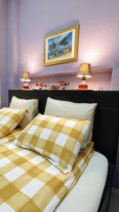 Olive Tree City Apartment في زغرب: سريرين في غرفة نوم مع مصباحين على الحائط