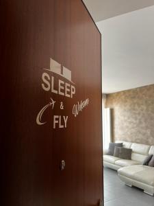 Una porta con un cartello che dice "dormi e vola". di SLEEP & FLY Bergamo Centro a Bergamo