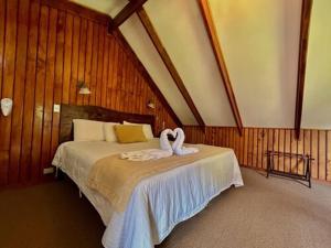 Un dormitorio con una cama con cisnes. en Hotel El Tirol en Alto del Roble