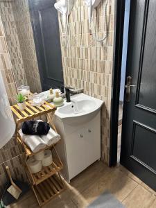 a bathroom with a white sink and a mirror at Kertész Vendégház in Siófok
