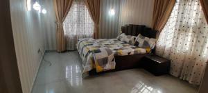 ein Schlafzimmer mit einem Bett in einem Zimmer mit Vorhängen in der Unterkunft Tourista Travel and Tours 