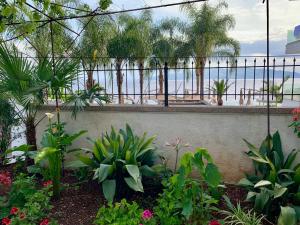 a garden with plants and a fence and the beach at Duka Apts in Sarandë